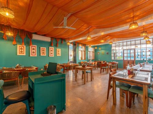 a restaurant with green walls and wooden tables and chairs at Moustache Jodhpur in Jodhpur