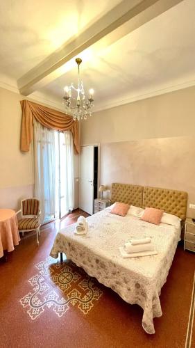 a bedroom with a large bed and a chandelier at Nonna's Affittacamere in Sanremo