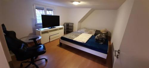 a bedroom with a bed and a desk and a chair at Unterkunft im Dorf in Schwallungen