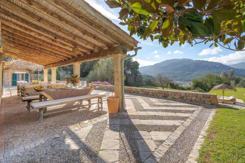 a patio with a table and a bench under a pergola at La Zalema in Esporles