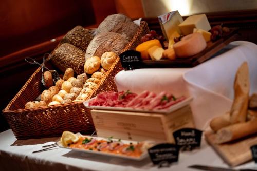 a table topped with baskets of different types of bread at Renaissance Lucerne Hotel in Luzern