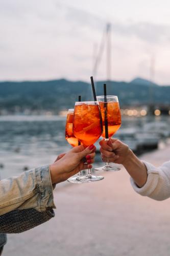 two people holding drinks in their hands at A-ROSA Gardasee in Salò