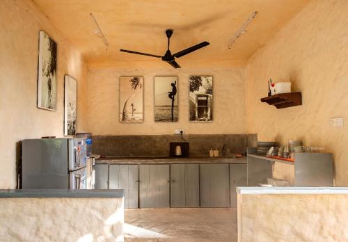 a kitchen with a refrigerator and a ceiling fan at Lime & Co Hostel in Weligama