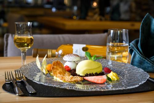a plate of food with ice cream and fruit on a table at Hotel Al Lago in Soraga