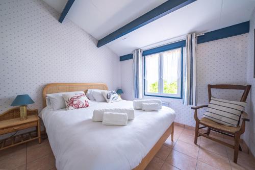 une chambre avec un lit avec une chaise et une fenêtre dans l'établissement Nouveau ! Maison familiale à 100m de la plage, à Saint-Trojan-les-Bains