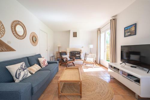 a living room with a blue couch and a tv at Nouveau ! Maison familiale à 100m de la plage in Saint-Trojan-les-Bains