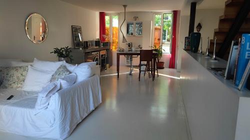 - un salon avec un lit blanc et une table dans l'établissement Le Duplex, à Angoulême