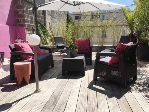 un patio avec des chaises et un parasol sur une terrasse dans l'établissement Le Duplex, à Angoulême