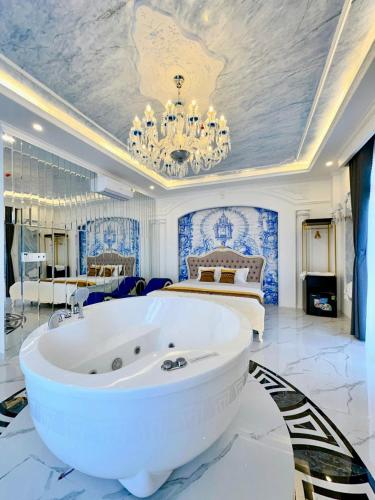 a large room with a large white tub in front of a bed at Sky Star Hotel in Can Tho