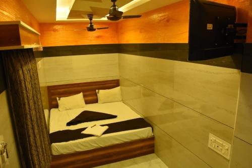 a small bed in a small room with at Vendha Sea Park in Velankanni