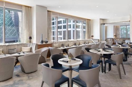 un restaurant avec des tables, des chaises et des fenêtres dans l'établissement AC Hotel by Marriott New York Downtown, à New York