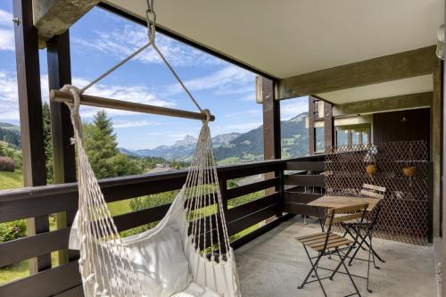 - un hamac sur le balcon d'une maison avec vue dans l'établissement Résidence Le Floréal - Megève, à Megève