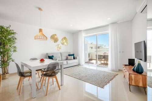 een witte woonkamer met een witte tafel en stoelen bij Orange Beach Ocean View, Porto de Mós VR29 in Lagos