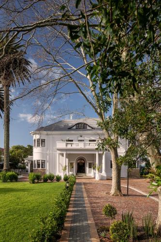 a white house with a walkway in front of it at Palm House Boutique Hotel and Spa in Cape Town