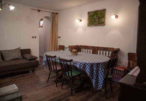 a living room with a table with chairs and a couch at Tulipános Vendégház in Szőlősardó
