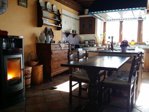 a kitchen with a table and a stove and a fireplace at Peropero' in Gattinara