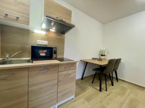 a kitchen with a sink and a table with a microwave at Hotel Aldo in Uničov