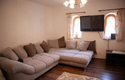 a living room with a couch and a flat screen tv at Tulipános Vendégház in Szőlősardó