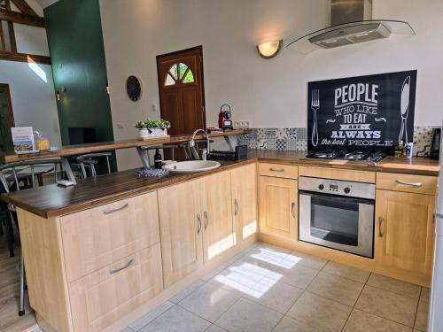 a kitchen with wooden cabinets and a sink and a stove at Lavoir - Séjour à Auxerre in Auxerre