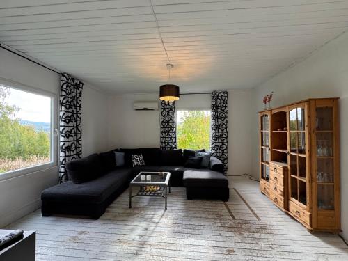 a living room with a black couch and a table at Charmig villa med 3 sovrum i Ljungaverk in Ljungaverk
