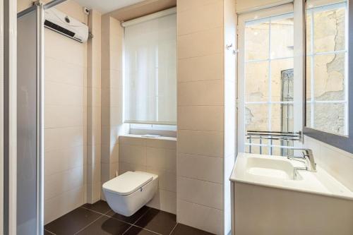 un bagno con un water, un lavandino e una finestra di Luxury Suite Reina Isabel a Granada