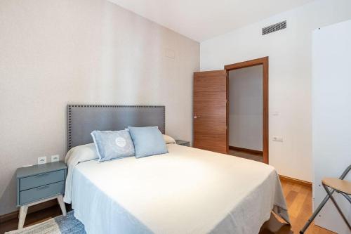 una camera da letto con un letto con cuscini blu di Luxury Suite Reina Isabel a Granada