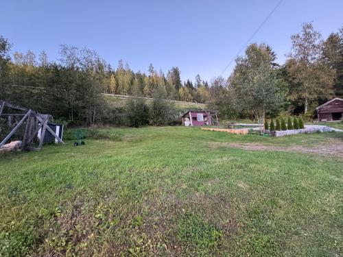 an open field with a house in the background at Charmig villa med 3 sovrum i Ljungaverk in Ljungaverk