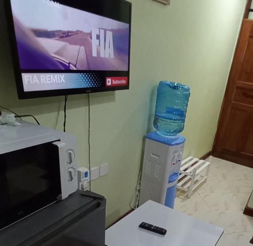 a tv and a microwave and a water bottle at Mtwapa june apartment 2 in Mombasa