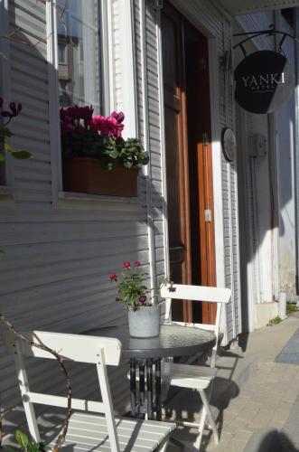 a table and two chairs on a porch with flowers at Yankı Hotel in Çekirge