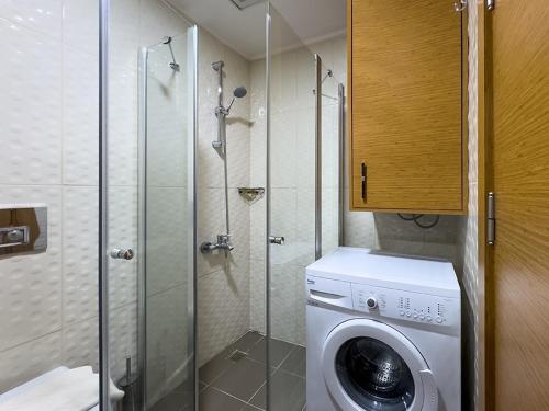 a bathroom with a washing machine and a shower at The Suites in Antalya