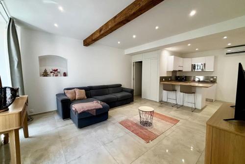 un salon avec un canapé et une cuisine dans l'établissement Magnifique studio dans l’hyper-centre d’Ajaccio, à Ajaccio