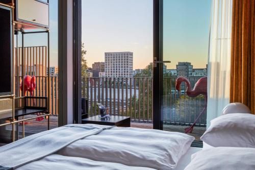 a bedroom with a bed and a large window at Roomers Munich, Autograph Collection in Munich