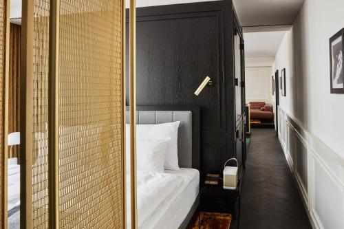 a bedroom with a white bed and a glass wall at Roomers Munich, Autograph Collection in Munich