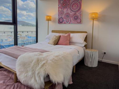 ein Schlafzimmer mit einem weißen Bett und einer großen weißen Decke in der Unterkunft Urban Retreat - 2 BDR 2 BTH Apartment in Phillip