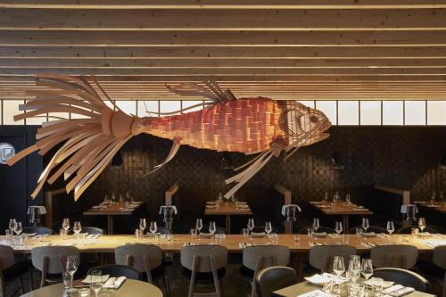 a giant fish hanging from the ceiling of a restaurant at Roomers Munich, Autograph Collection in Munich