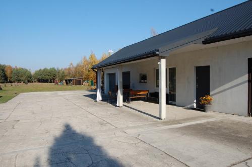 a building with a patio with a table on it at Letnia Oaza "Forsycja" in Sobienie Jeziory