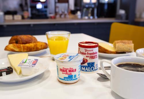 a table with breakfast food and a cup of coffee at B&B HOTEL Bourges 2 in Bourges