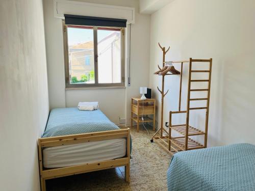 a bedroom with two beds and a ladder and a window at La Casa Sul Pontile in Vasto