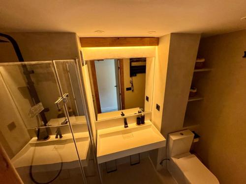 Un baño con ducha, inodoro y espejo. en Sierra Nevada Haven, en Sierra Nevada