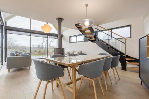 une salle à manger avec une table et des chaises et un escalier dans l'établissement Villa Mer - 180m de la plage, à Penmarcʼh