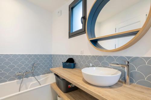 a bathroom with a sink and a mirror at Villa Mer - 180m de la plage in Penmarcʼh