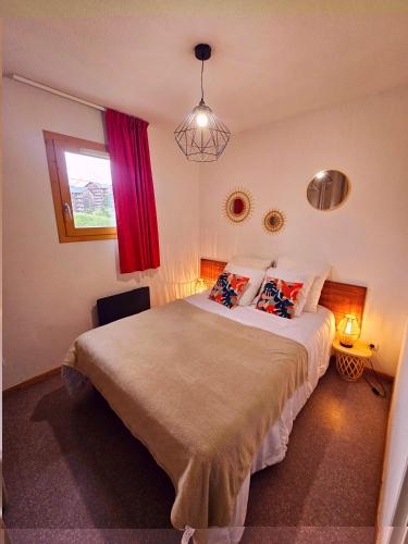 une chambre avec un grand lit avec des oreillers et une fenêtre dans l'établissement Appart 2 pièces avec balcon, à Saint-Étienne-en-Dévoluy