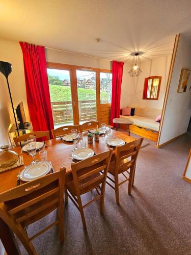 - une salle à manger avec une table et des chaises dans l'établissement Appart 2 pièces avec balcon, à Saint-Étienne-en-Dévoluy