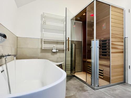 a bathroom with a tub and a shower at Ferienwohnung Ostseewind 10 Parkvillen Carlota und Candela Baabe in Baabe