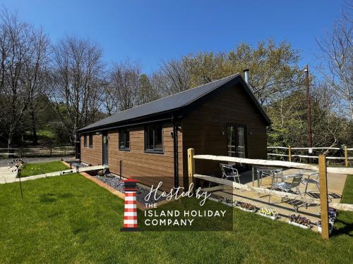 a small cabin in a yard with a grass yard at Cherry Lodge in Godshill