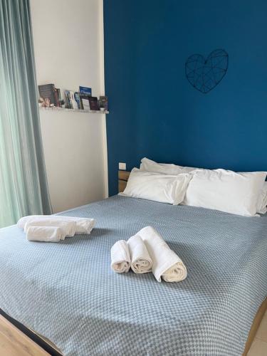 two towels on a bed with a blue wall at Sea La Vie - Terrazza sul mare in Agropoli