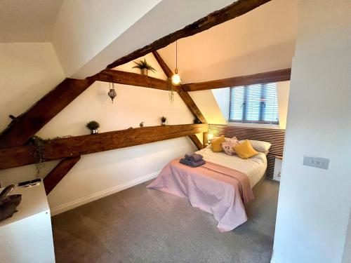 a attic room with a bed and a window at MC 2 bed central location - no parking in Stratford-upon-Avon