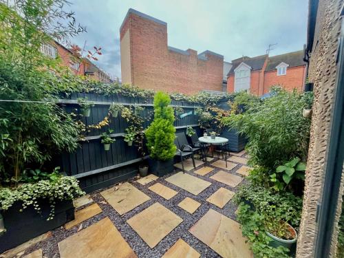a garden with a table and chairs and a fence at MC 2 bed central location - no parking in Stratford-upon-Avon
