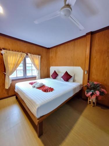 a bedroom with a large white bed with a window at Bang Yan Rimlay in Ko Yao Noi