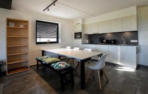 a kitchen with a table and chairs in a room at Hoeve Ten Rooden Duifhuize in Sint-Denijs